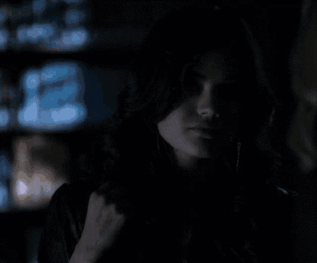 a close up of a woman 's face in the dark with a blurry background