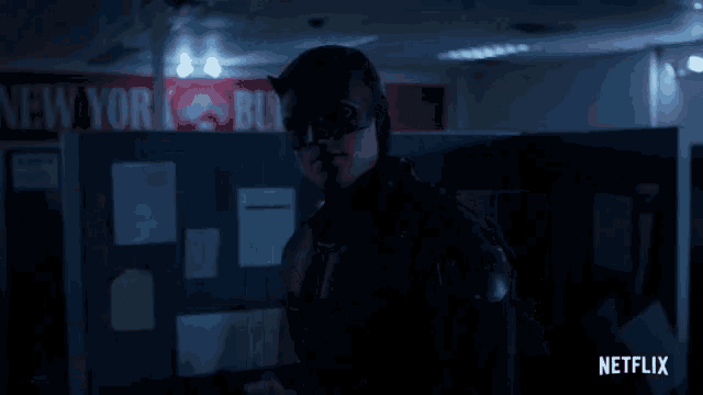 a man in a daredevil costume stands in front of a sign that says new york city