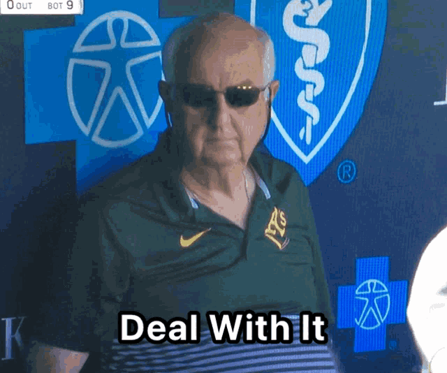 an older man wearing sunglasses and a nike shirt stands in front of a sign that says deal with it