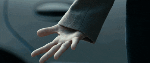 a close up of a person 's hand reaching out towards a car door