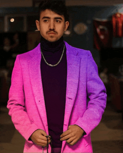 a man wearing a pink jacket and purple turtleneck