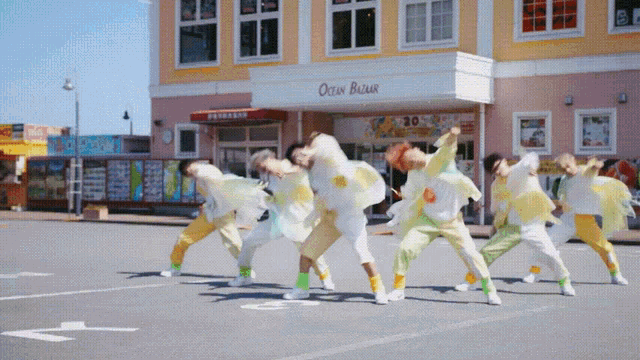 a group of people are dancing in front of a store called ocean breeze