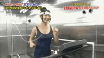 a woman in a blue tank top is running on a treadmill with chinese writing on the wall behind her