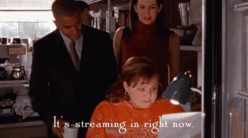 a little girl is sitting in front of a laptop with the words " it 's streaming in right now " written above her