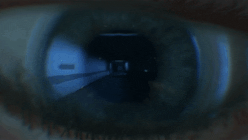 a close up of a person 's eye looking into a dark tunnel