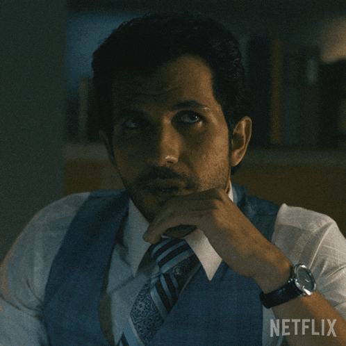 a man wearing a vest and tie has a netflix logo on his chest