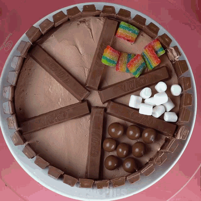 a kitkat cake with candy and marshmallows on a plate