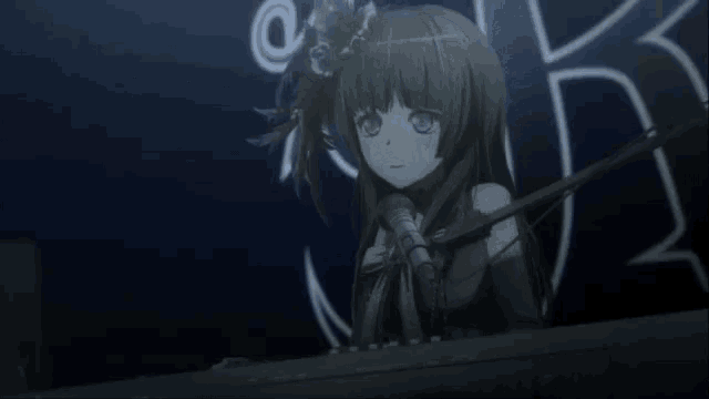 a girl is singing into a microphone in front of a sign that has the letter k on it
