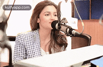 a woman is sitting in front of a microphone in a room .