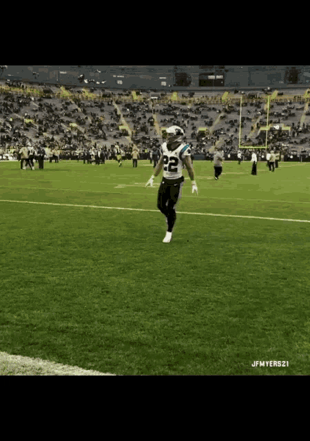 a football player with the number 22 on his jersey stands on the field