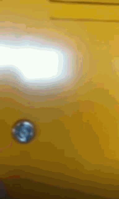 a close up of a yellow object with a blue circle in the middle of it .