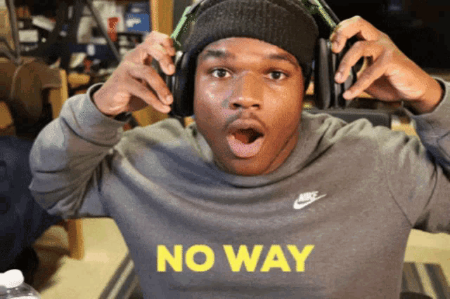 a man wearing headphones and a nike sweatshirt says no way