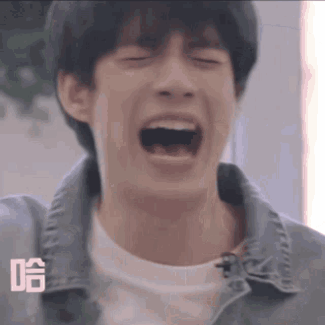 a young man with his mouth open is making a funny face .