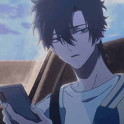 a man is sitting in the back seat of a car looking at his phone