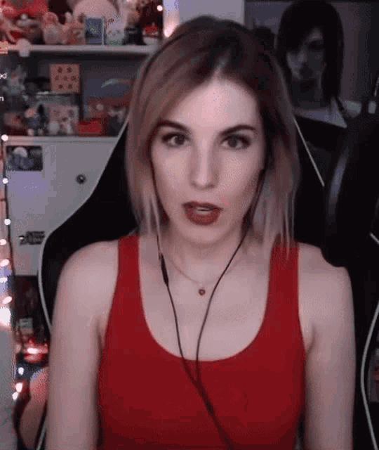 a woman wearing a red tank top and headphones