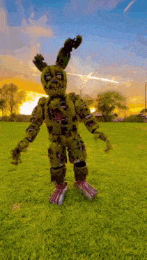 a bunny costume is standing in a grassy field .