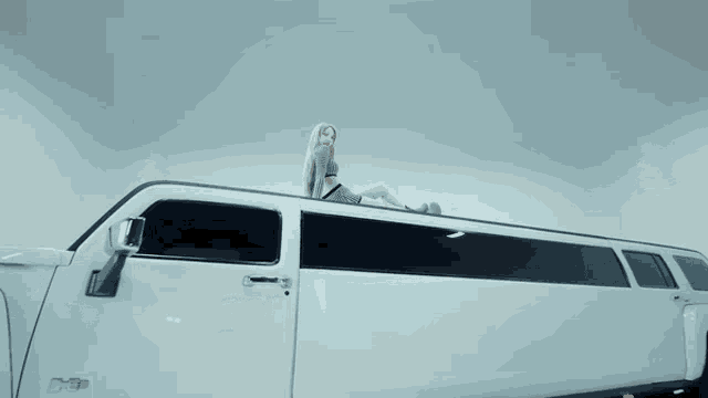 a woman is laying on the roof of a white van