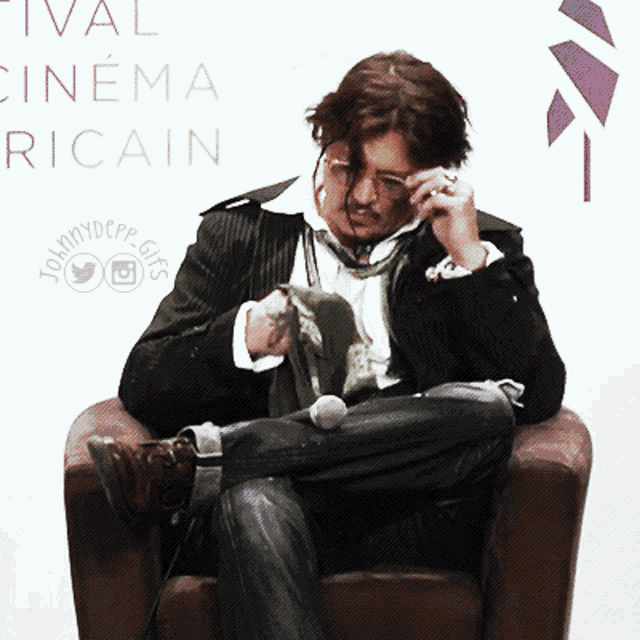 a man sits in a chair in front of a sign that says " cinema ricain "