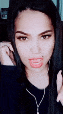 a close up of a woman 's face with her mouth open and ear buds on