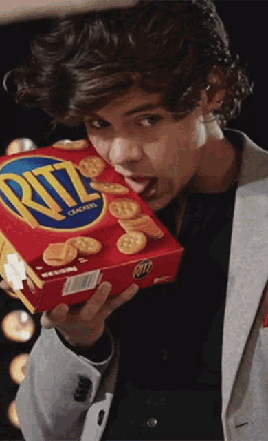 a man holds a box of ritz crackers in his hand