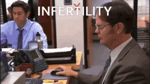 a man sitting at a desk with the word infertility written on the screen