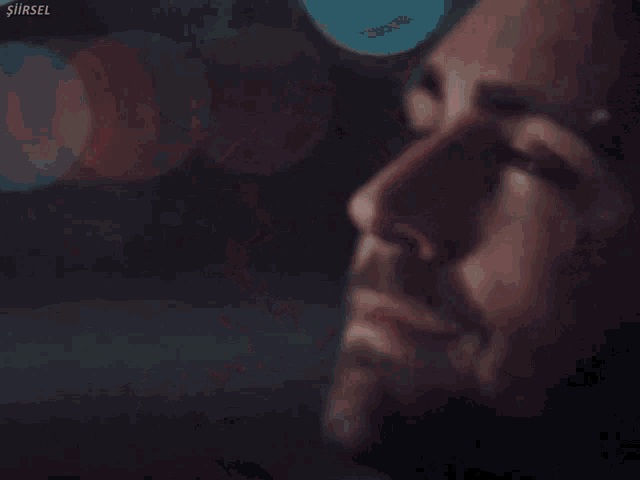 a close up of a man 's face with the name şirsel on the bottom right