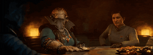 a man with a beard is sitting at a table with two other men