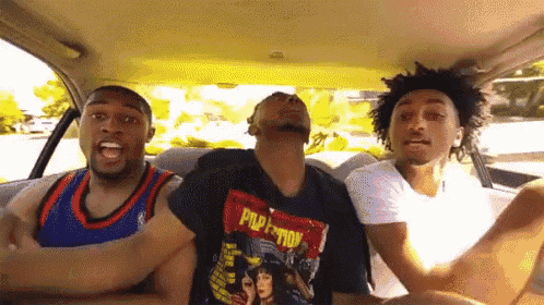 three men are sitting in a car with one wearing a pulp fiction t-shirt