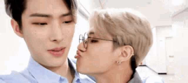 two men are kissing each other on the cheek .