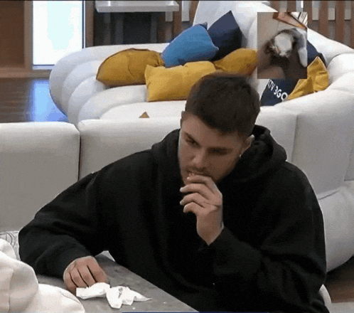 a man sitting in front of a white couch with a picture of a person on it