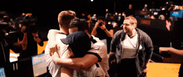 a group of men hugging each other with one wearing a shirt that says ' us air force ' on it