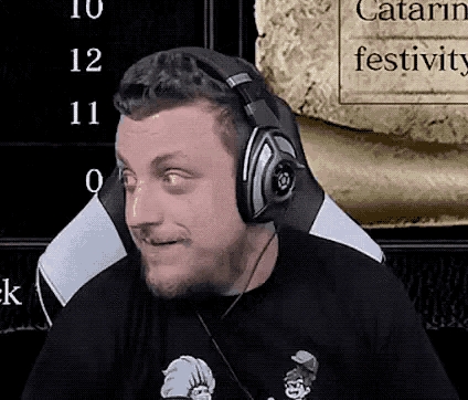 a man wearing headphones and a black shirt is sitting in a chair .