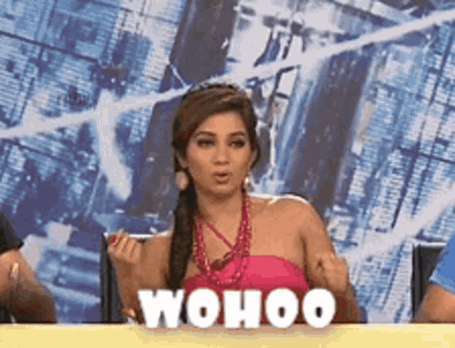 a woman in a pink top is sitting at a table with the word " wohoo " on it