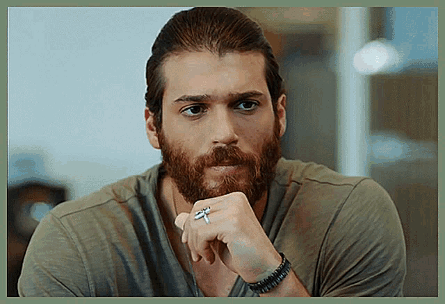 a man with a beard wears a ring on his finger