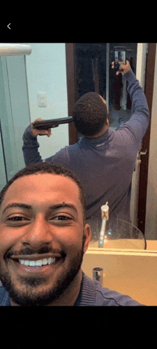 a man is taking a picture of himself with a gun