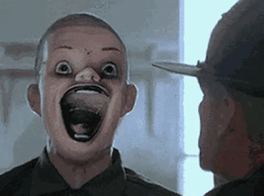 a man with a strange face is looking at another man .