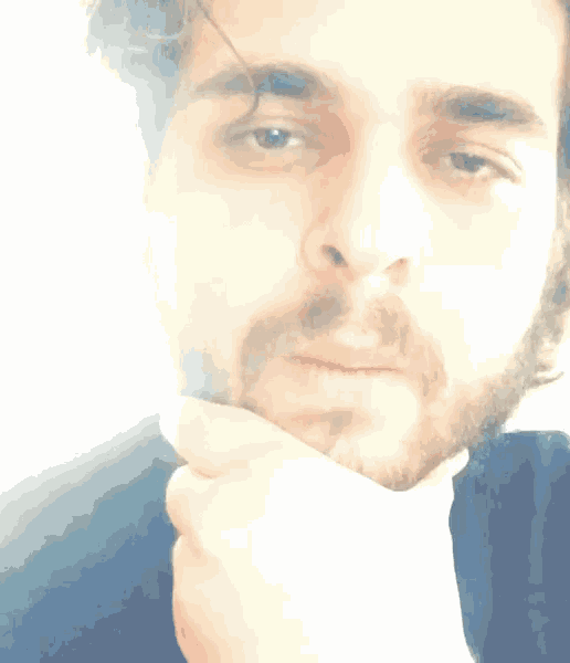 a man with a beard is holding his chin with his hand