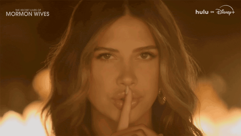 a woman holds her finger to her lips with the words " the secret lives of mormon wives " on the bottom
