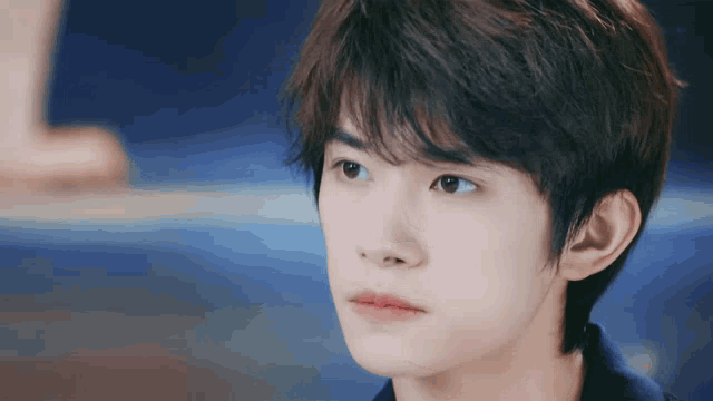 a close up of a young man 's face with a serious look on his face