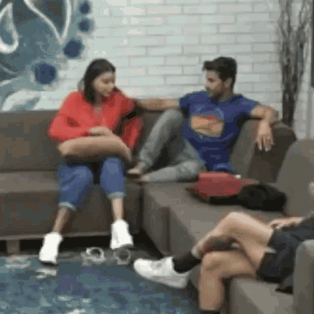 a man and woman are sitting on a couch talking