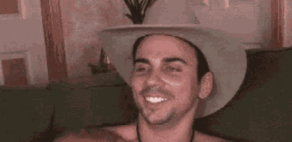 a man in a cowboy hat is making a funny face .