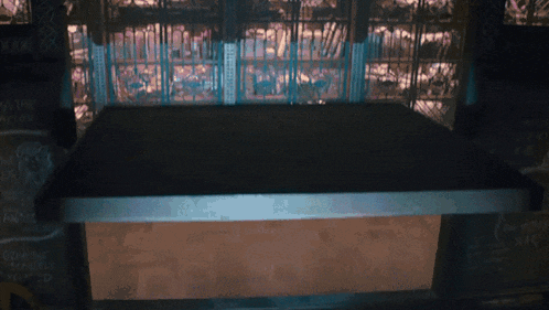 a dark room with a table and a sign that says ' a & a ' on it