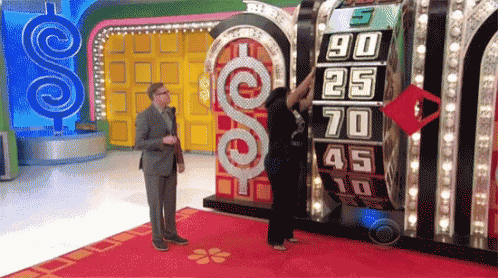 a man and a woman are standing in front of a machine that says 90 25 70 45 10 on it