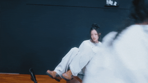 a girl in a white shirt is sitting on a couch