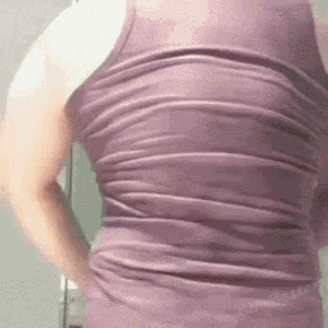 a woman is wearing a purple tank top with a ruffled back .