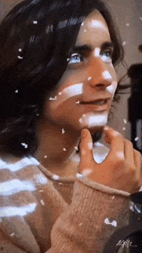 a close up of a person 's face with snow falling on it