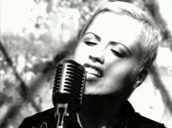 a woman singing into a microphone in a black and white photo .