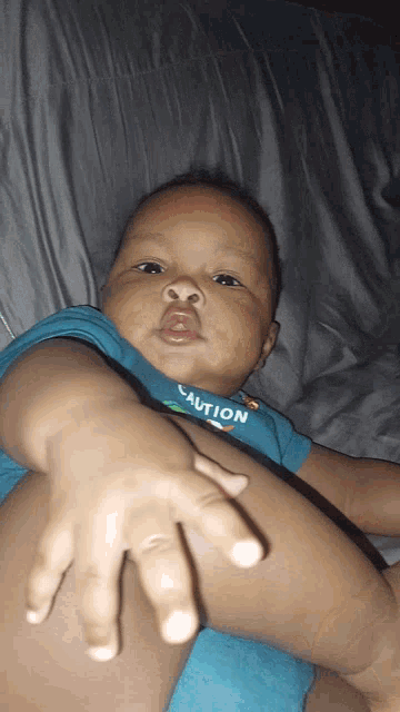 a baby wearing a shirt that says caution on it