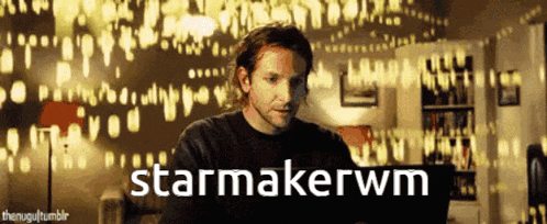 a man sitting in front of a wall with the words starmakerwm written on it