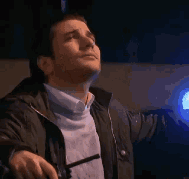 a man in a jacket is holding a flashlight in his hand